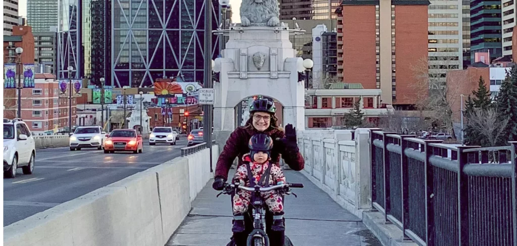 woman biking with child in winter